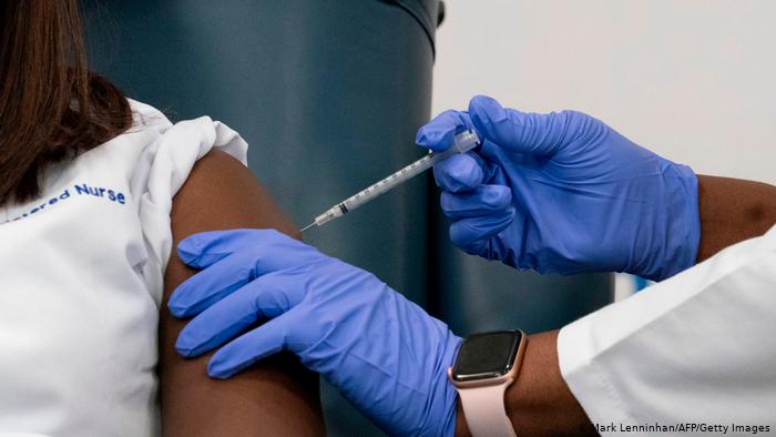 Vaccinating a woman against COVID-19.
